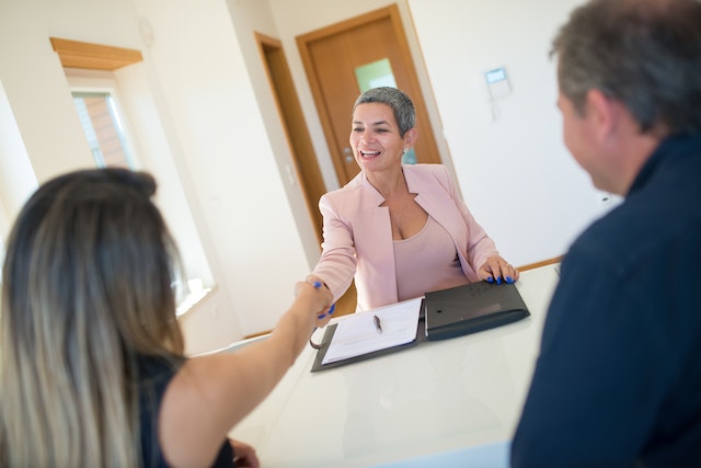 two tenants reviewing a lease agreement with a landlord